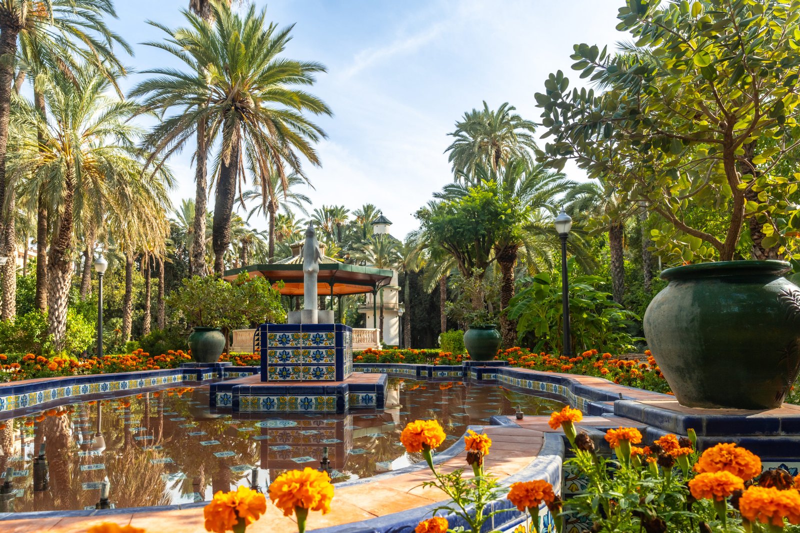 Templete or pergola and the fountain with flowers in the palm grove park in the city of Elche. Spain